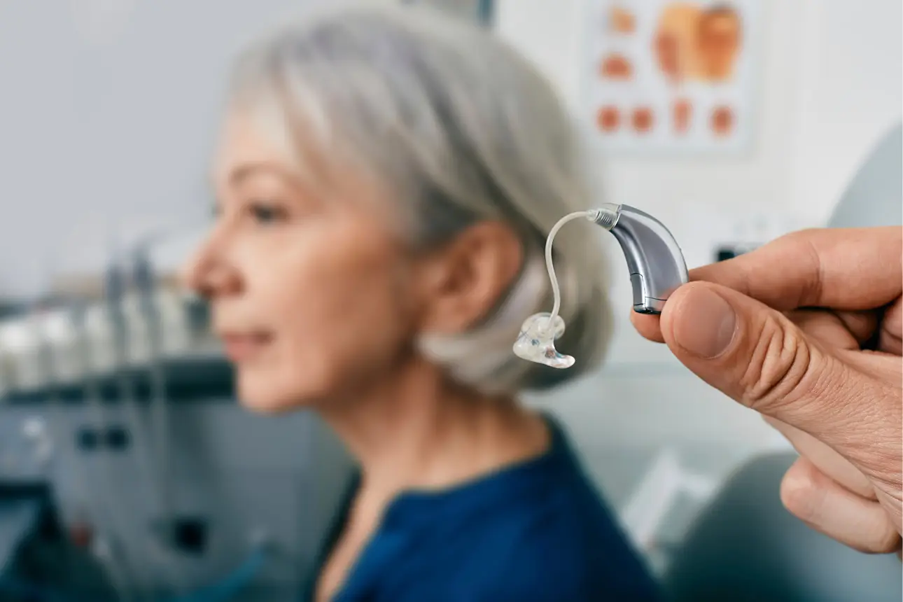 doctor offering hearing aid to medicare beneficiary