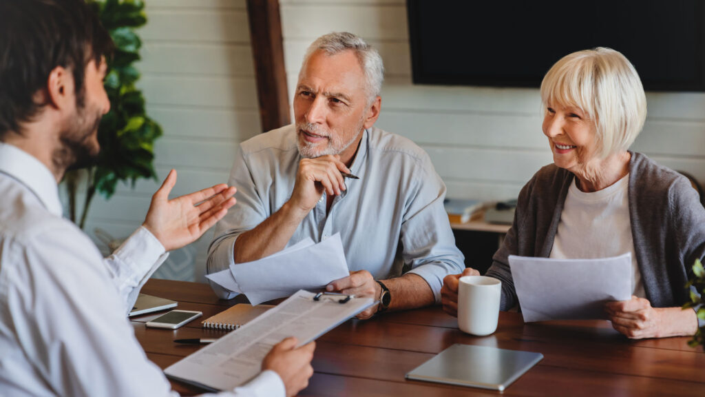 Senior couple discussing Medicare plan options with a Medicare advisor in Michigan