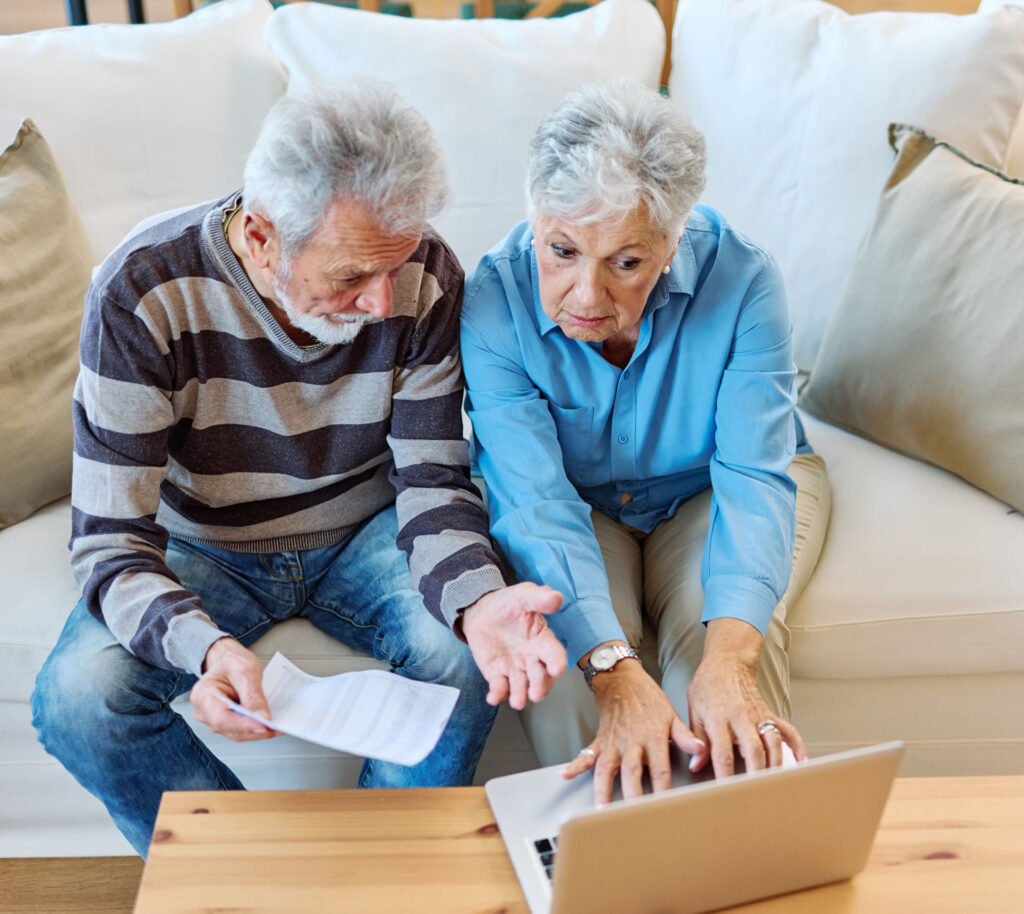 Does Medicare Cover Auto Accident Injuries in Michigan? Senior couple reviewing Medicare and auto accident coverage information on a laptop