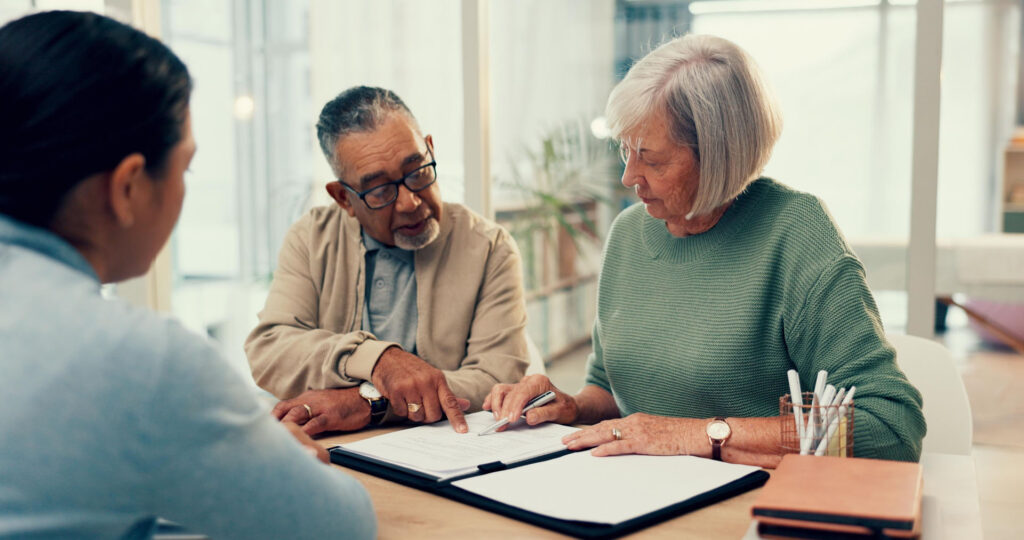 Senior couple reviewing Medicare plan paperwork with an insurance advisor